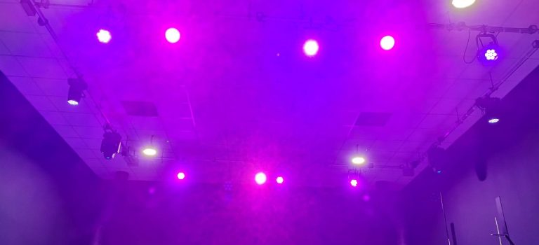 LED lighting Colourful stage lights illuminating a dark auditorium ceiling.